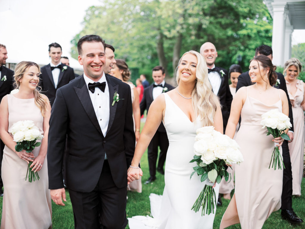 The wedding party walks together in the backyard of the Mansion at Brecknock Hall.