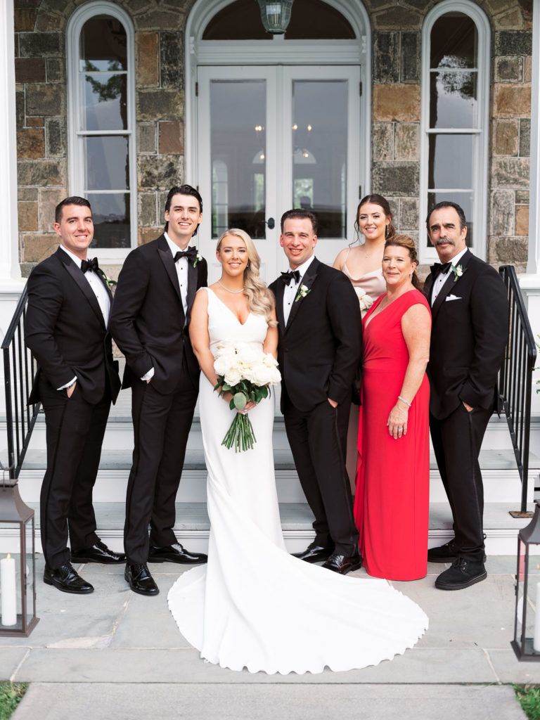A family photograph of the bride and groom. on the steps at Brecknock Hall.