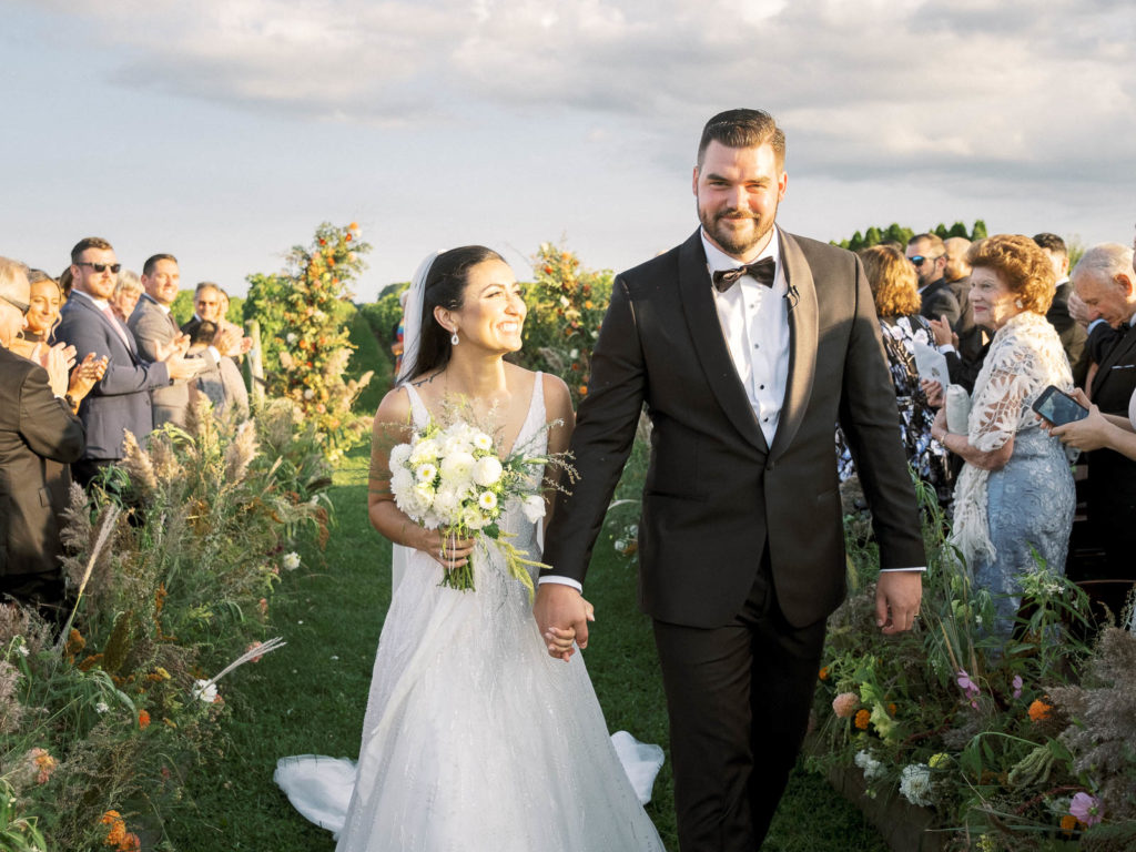 Bride and groom walk down aisle during their Long Island Vineyard Wedding.