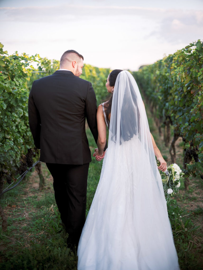 Bride and groom walk away at RGNY in vines.