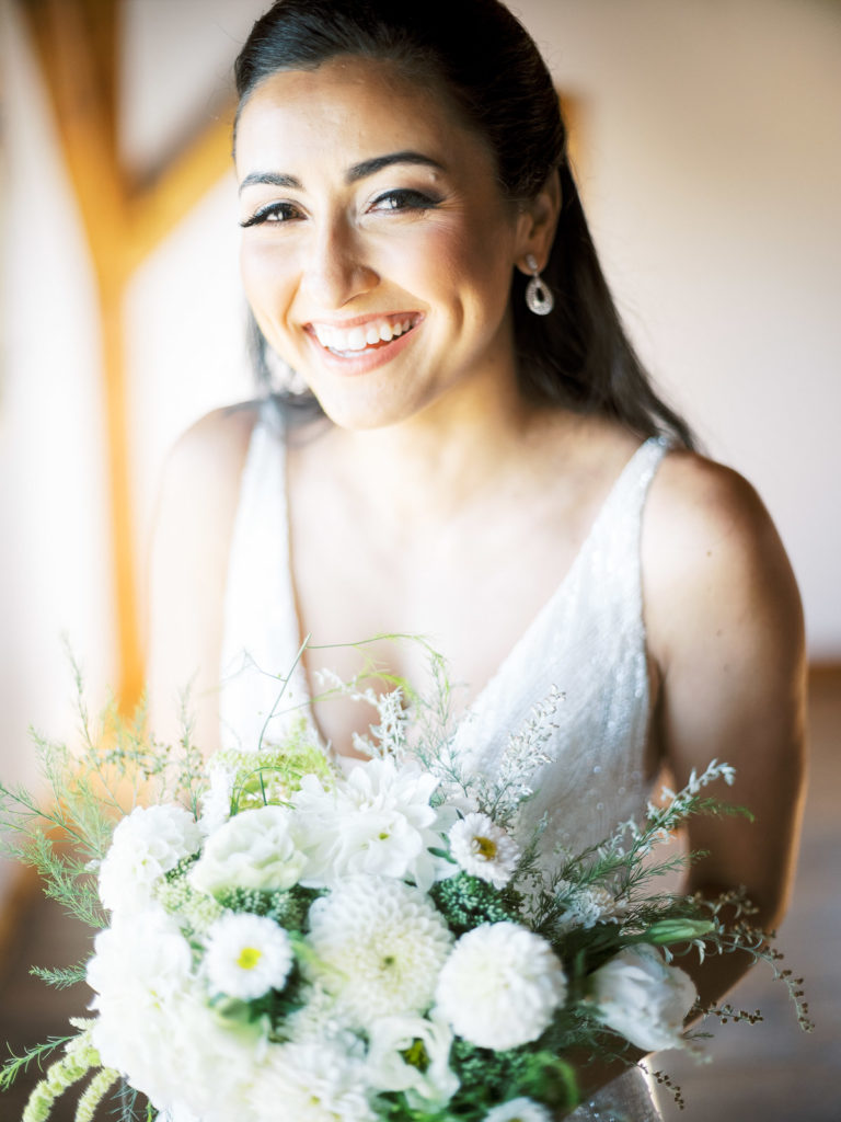 The Long Island Vineyard Wedding bride with her hometown flower co boquet in her enaura bridal dress.