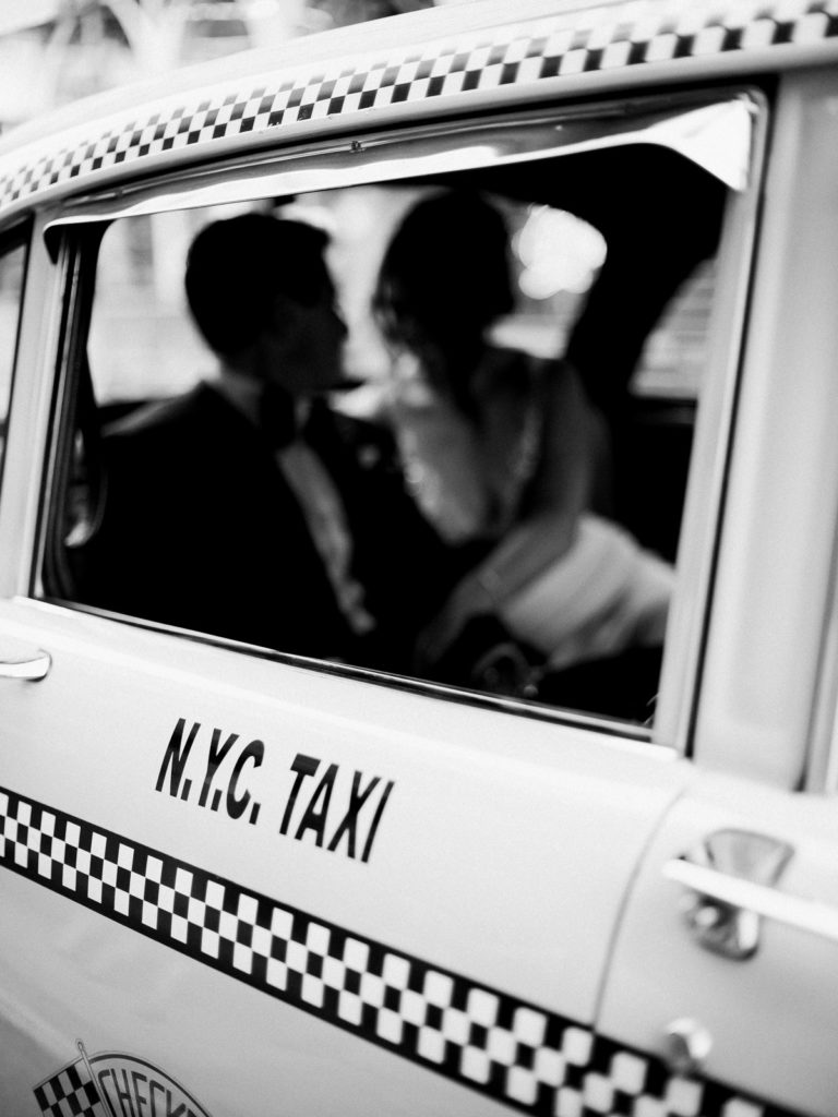 Bride and groom look at each other inside The Checkered Cab NYC.