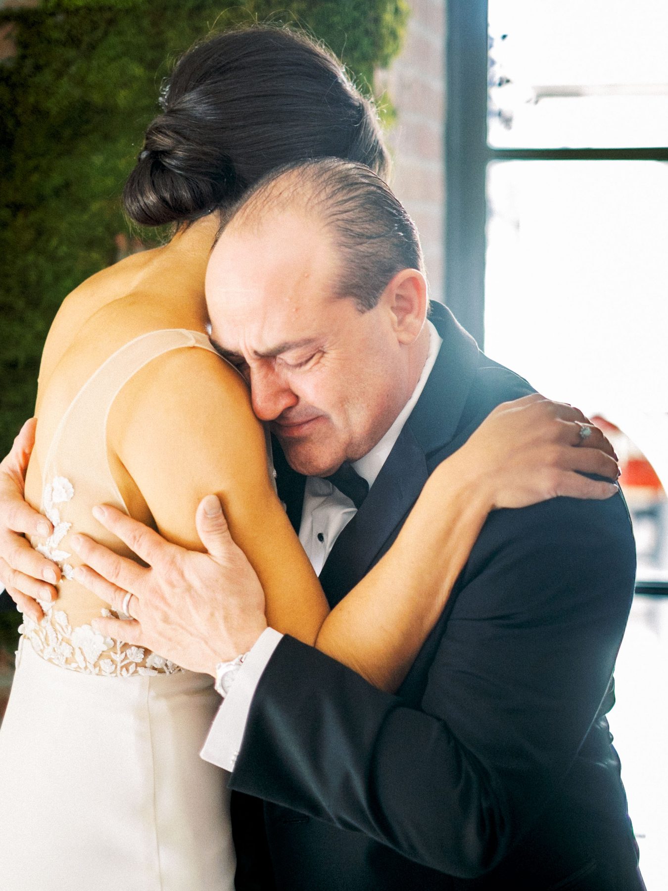 A man closes his eyes as he embraces a wedding guest.